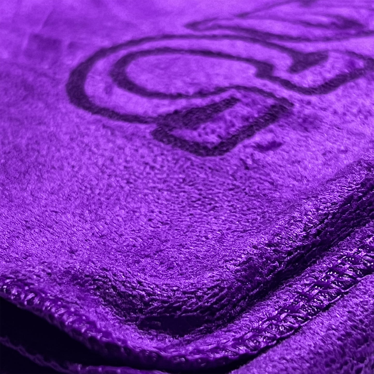Close-up of a purple towel with Omega Psi Phi logo on it
