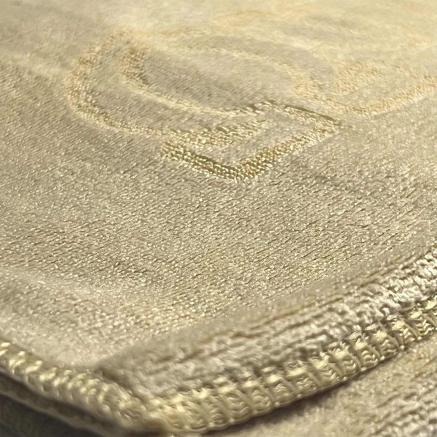 Close-up of an old gold colored microfiber towel with Omega Psi Phi logo