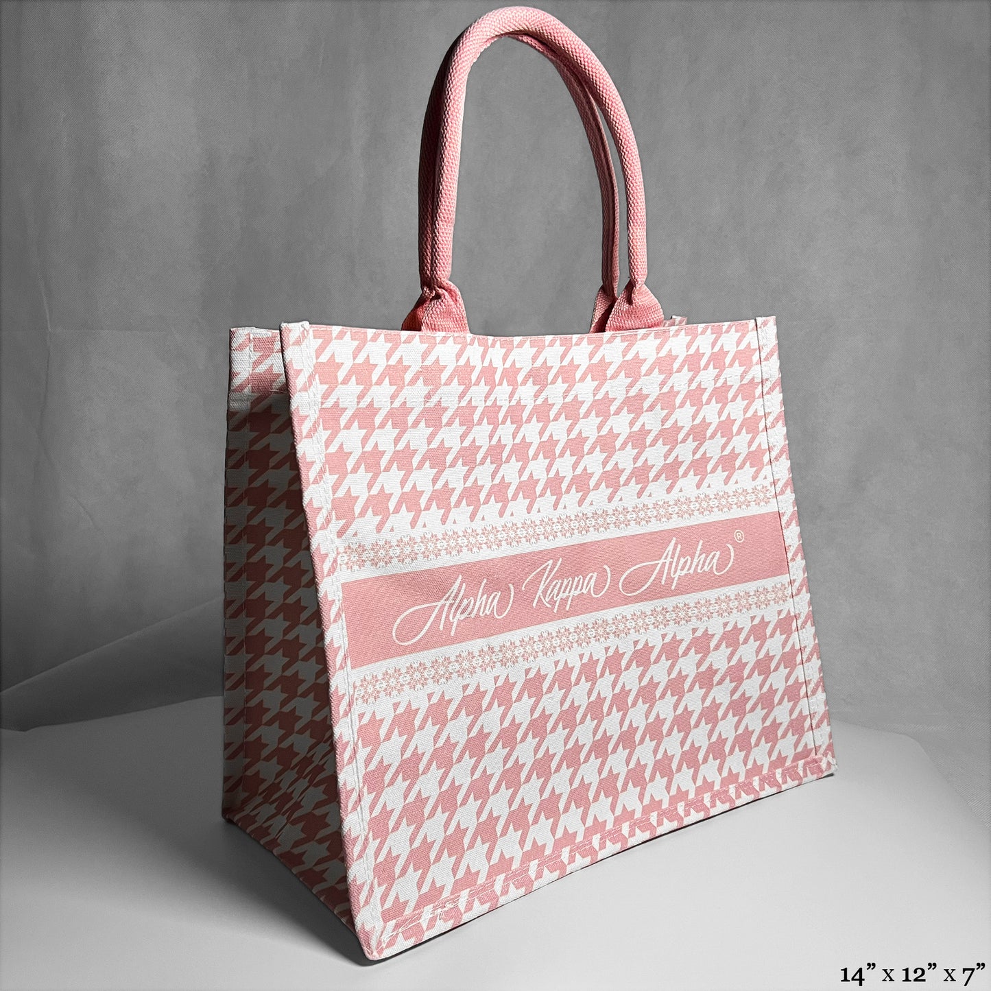 tote bag with pink and white houndstooth pattern. Alpha Kappa Alpha text in the center.
