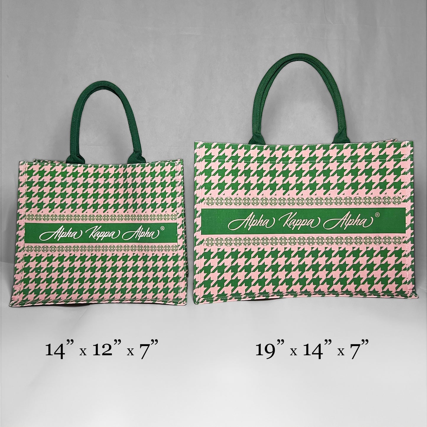 Two tote bags with green and pink houndstooth pattern and 'Alpha Kappa Alpha' text showing the size comparison. The left bag is the smaller version at 14 inches by 12 inches by 7 inches. The right bag is the larger version at 19 inches by 14 inches by 7 inches.