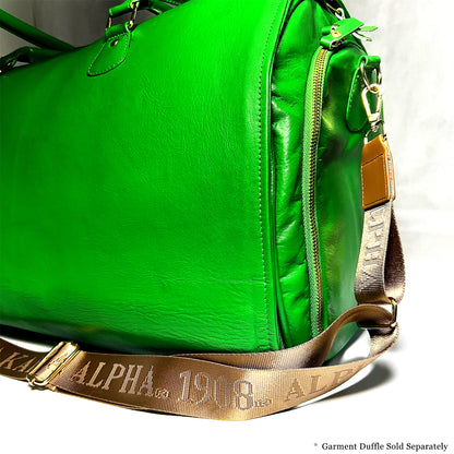 Bronze/Gold bag strap with debossed 'Alpha Kappa Alpha 1908' branding featured on a green leather duffle bag.  Notice: Garment Duffle Sold Separately