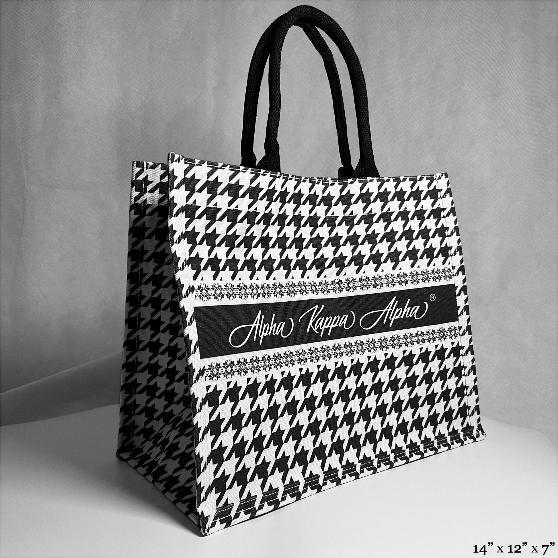 tote bag with black and white houndstooth pattern. Alpha Kappa Alpha text in the center. 