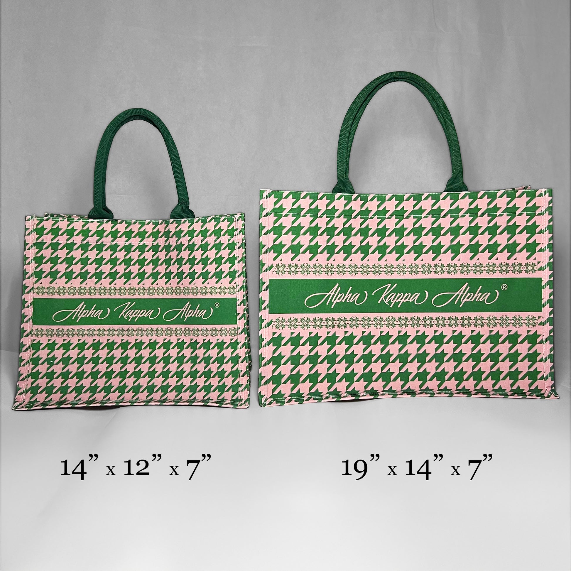 Two tote bags with green and pink houndstooth pattern and 'Alpha Kappa Alpha' text showing the size comparison. The left bag is the smaller version at 14 inches by 12 inches by 7 inches.  The right bag is the larger version at 19 inches by 14 inches by 7 inches.